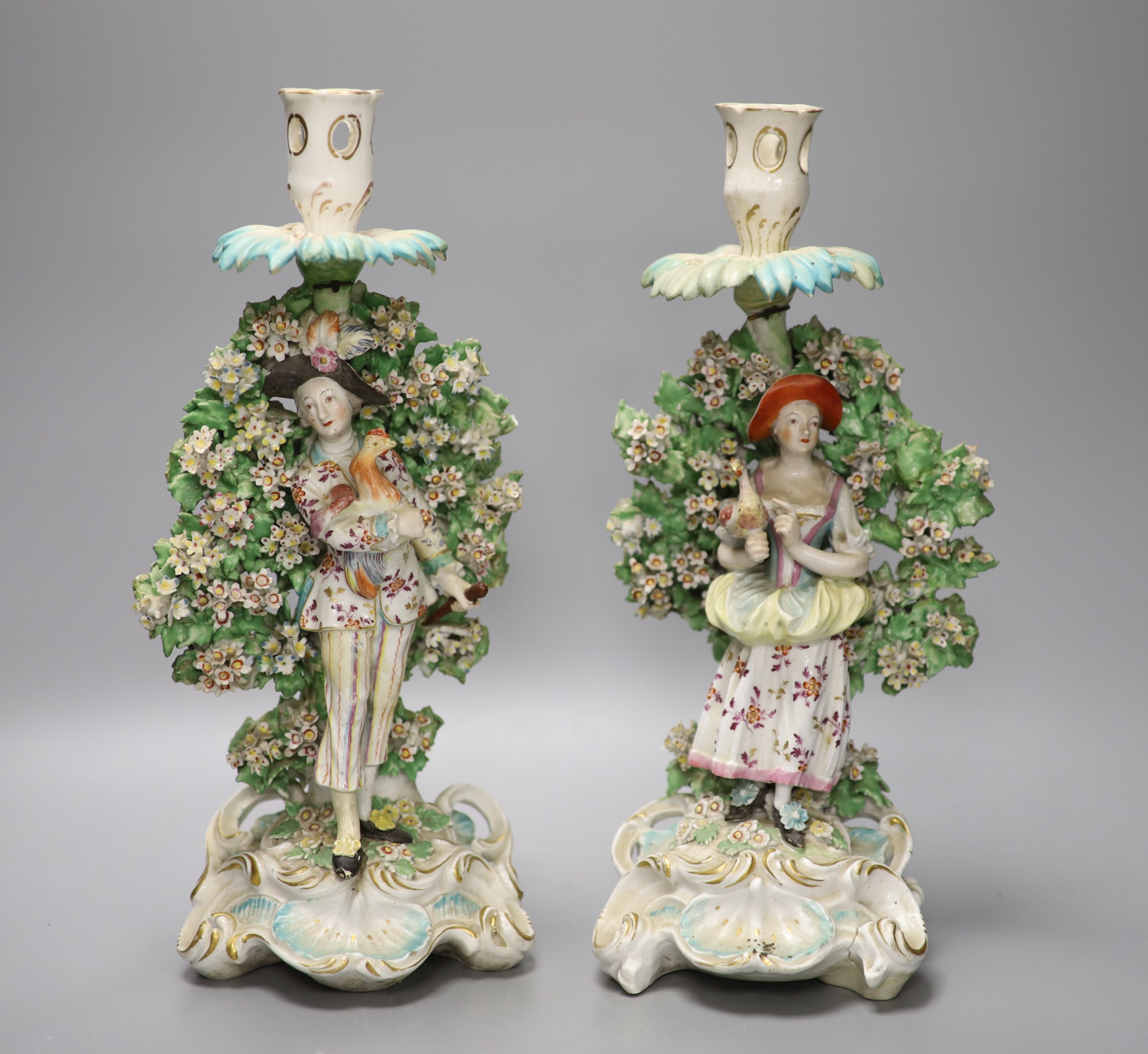 A pair of Derby bocage figural candlesticks, of the Italian farmer and his wife, c.1770, height 31.5cm